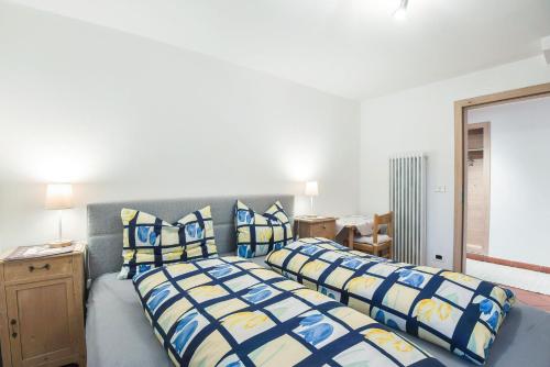 a bedroom with two beds with blue and yellow pillows at Apt Julia - Haus Ivo in Santa Cristina Gherdëina