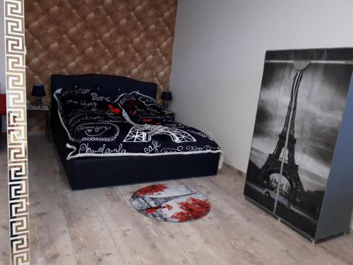a bed with a black comforter with the eiffel tower at Apartament centrum Sienkiewicza WIEŻA EIFFLA PROMENADA -KLIMATYZACJA- WYJĄTKOWY in Kielce