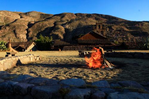a fire in a field with mountains in the background at San Agustin Monasterio de la Recoleta in Urubamba