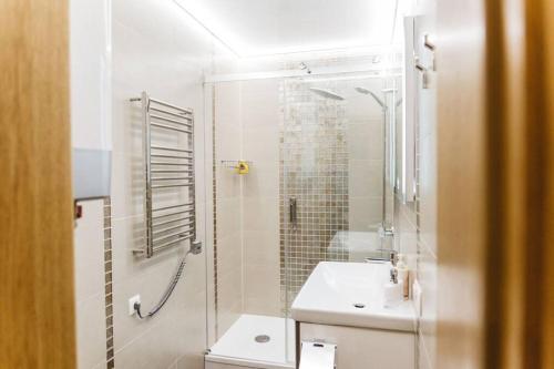 een badkamer met een douche en een wastafel bij Brand-New Deluxe Apartment in Liepāja in Liepāja