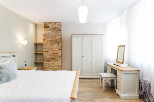 a bedroom with a bed and a desk with a mirror at Brand-New Deluxe Apartment in Liepāja in Liepāja