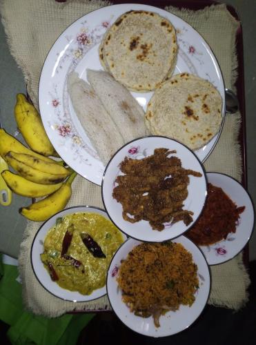 a table topped with plates with different types of food at Mango Roots in Gampaha