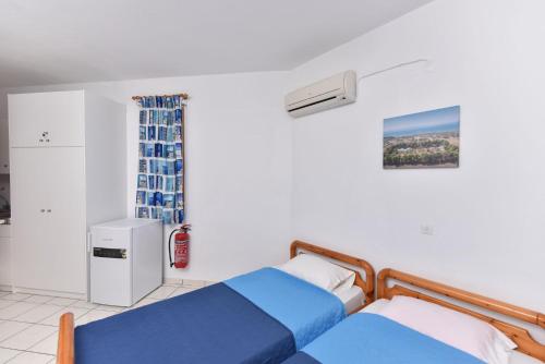 - une chambre avec deux lits et un réfrigérateur dans l'établissement Eretria Park Studios, à Eretria