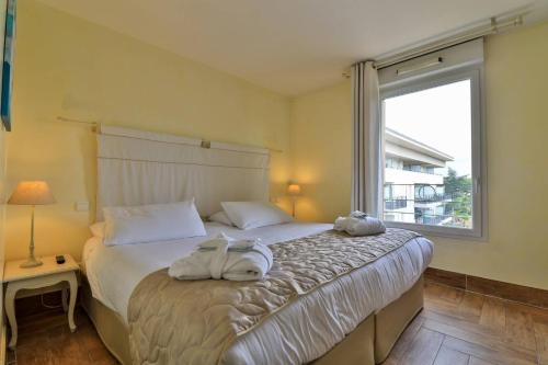 a bedroom with a bed and a window at Best Western Plus Soleil et Jardin in Sanary-sur-Mer