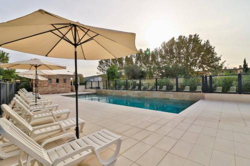 a group of chairs and an umbrella next to a pool at Soleil et Jardin in Sanary-sur-Mer