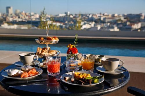 a tray of food on a table with a view at Memmo Príncipe Real - Design Hotels in Lisbon