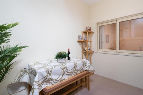 a table with a wine bottle and a plant on it at Host Wise - Anna Flats in Vila Nova de Gaia