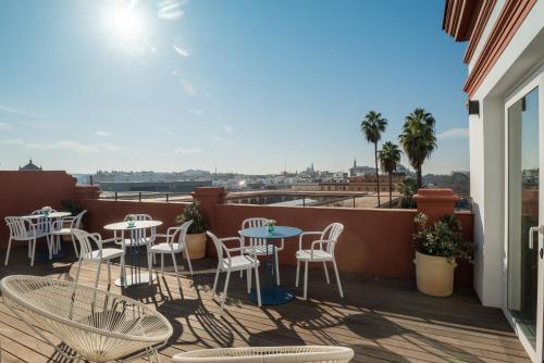 un patio con tavoli e sedie su un balcone di nüa torreón a Siviglia