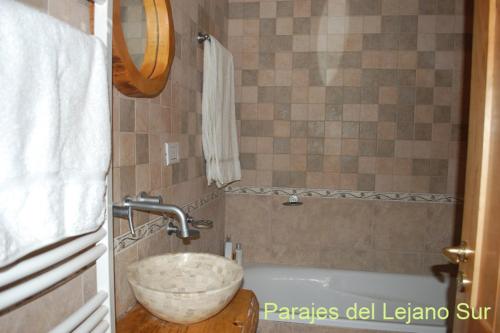 a bathroom with a bowl sink and a tub at Parajes del lejano sur Cabaña El Patacón in Moquehue