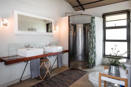 y baño con 2 lavabos y ducha. en Serondela Lodge en Mbalastinte