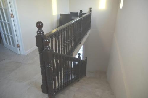 a staircase with a black railing in a hallway at Ixoras Beach Apartments in Saint Peter