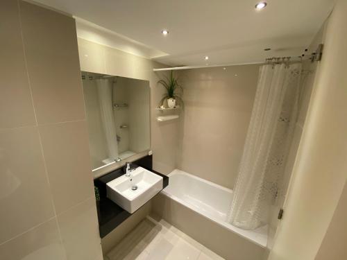 a white bathroom with a sink and a bath tub at Privilege Studios in Terrazas Polo in Buenos Aires