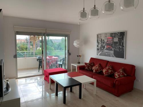 a living room with a red couch and a table at Aquamaris-Denia Apartamento espectacular in Denia