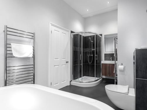 uma casa de banho branca com um chuveiro e um WC. em Qudos em Salisbury