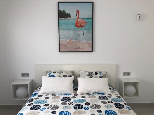 ein Schlafzimmer mit einem Bett mit einem Bild eines Flamingos in der Unterkunft Casa Ribalta in San Pedro del Pinatar