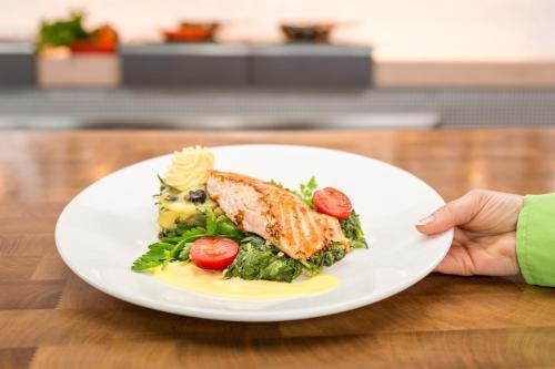 a person holding a plate of food on a table at Holiday Inn Berlin City East Side by IHG in Berlin