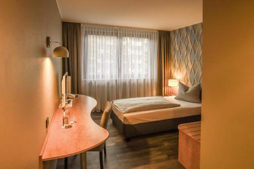 a small bedroom with a bed and a window at Eurostar Hotel in Castrop-Rauxel