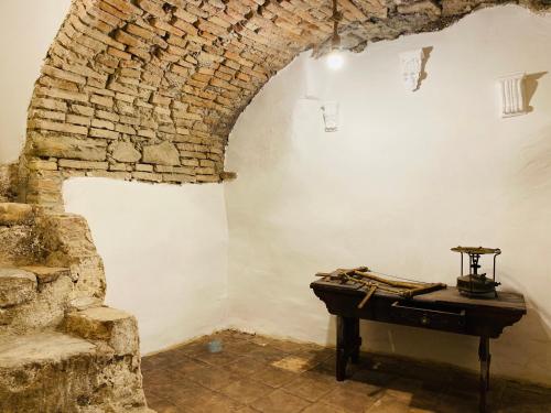 a room with a stone wall and a piano at Ca' del Borgo in Venosa