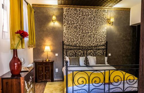 a bedroom with a bed with a black and yellow bedspread at Pensiunea Luna in Buşteni