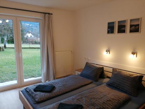 a bedroom with two beds and a large window at Parkweg Lodge in Faak am See