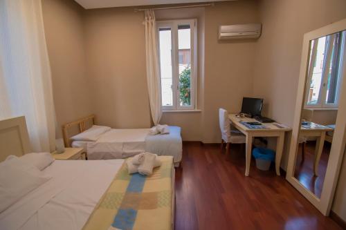 レッジョ・ディ・カラブリアにあるCasual Stay Cairoliのベッドが2つと机とコンピューターがある部屋