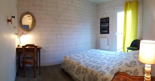 une chambre avec un lit, une table et un miroir dans l'établissement Escapade en Provence, bord de mer à 10 minutes, à Puget-sur Argens