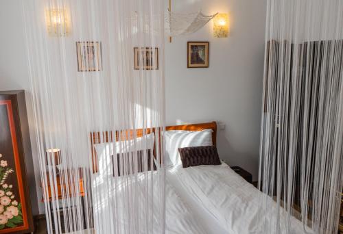 a bedroom with a canopy bed with white sheets at Pensiunea Luna in Buşteni