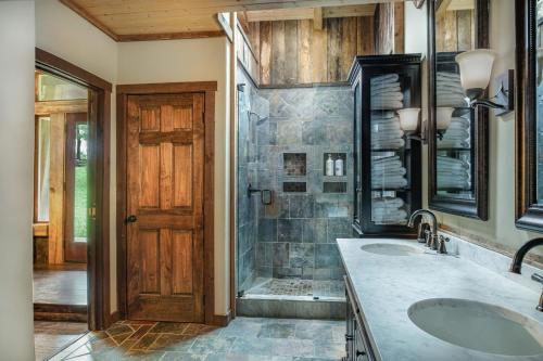 a bathroom with two sinks and a wooden door at Charming Bunkhouse, Private Porch, Double Shower in Franklin
