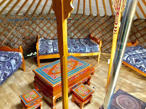 Zimmer mit 2 Betten und einem Tisch in einer Jurte in der Unterkunft Takhi Resort in Yoliin Hural