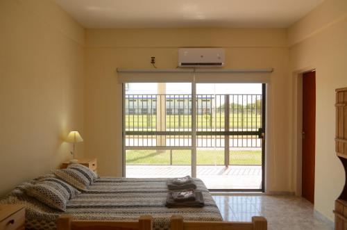 a bedroom with a bed and a large sliding glass door at City Apartments Formosa in Formosa