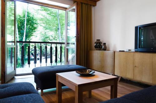 uma sala de estar com uma televisão e uma mesa em Summer house near lake em Bukovec