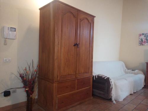 a large wooden cabinet in a room with a couch at Appartamento via della Posterna Spoletium in Spoleto