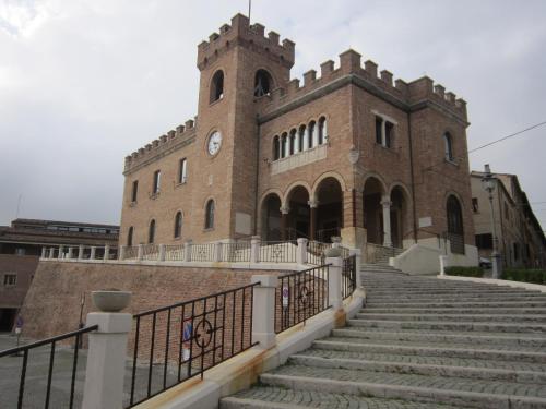a large brick building with stairs in front of it at Casa Vacanze - B&B La Casetta in Mondolfo