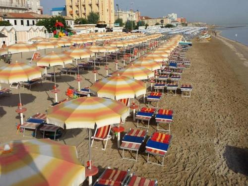 a bunch of chairs and umbrellas on a beach at Casa Vacanze - B&B La Casetta in Mondolfo
