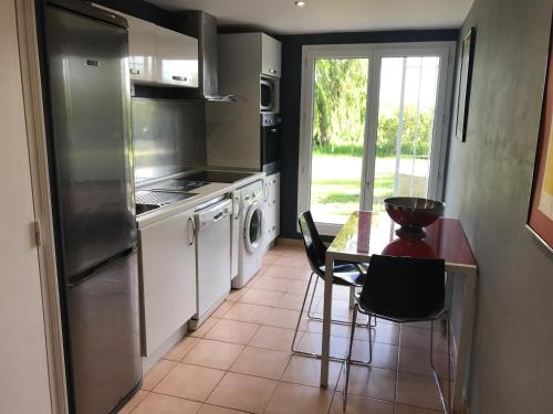 La cuisine est équipée d'une table, d'une cuisinière et d'un réfrigérateur. dans l'établissement La Bastide Plein Sud de Marignan, à Saint-Gilles