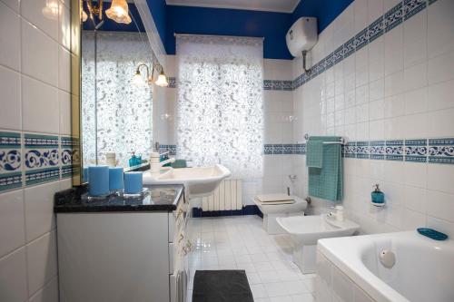 baño azul y blanco con 2 lavabos y aseo en Casale Godenza, en Matelica