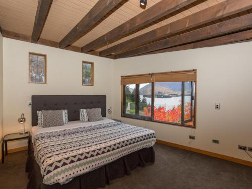 a bedroom with a large bed and a window at Crows Nest - Queenstown Holiday Home in Queenstown