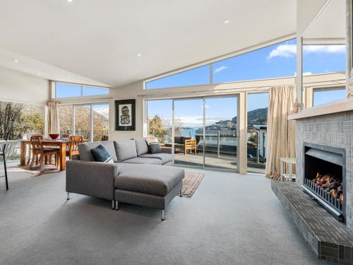 a living room with a couch and a fireplace at Lake Views on Yewlett - Queenstown Holiday Home in Queenstown
