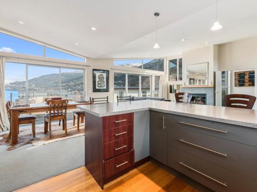 a large kitchen with a table and a dining room at Lake Views on Yewlett - Queenstown Holiday Home in Queenstown