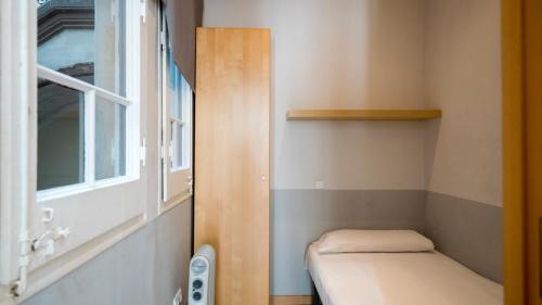 バルセロナにあるApartamento Entençaの窓際のベンチ付きの小さな客室です。