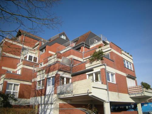 a red brick building with balconies on it at Sonnendeck Nordsee in Horumersiel