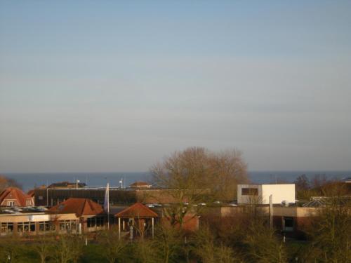 a group of buildings in a city with trees at Sonnendeck Nordsee in Horumersiel