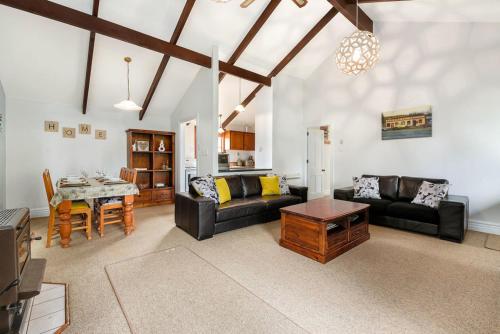 a living room with two couches and a table at Central Peach - Queenstown Holiday Home in Queenstown