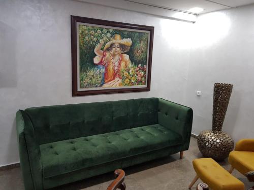 a green couch in a living room with a painting at See&Sun in Ashdod
