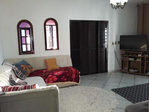 un soggiorno con un divano e una TV di Hostel do Enzo a Itanhaém