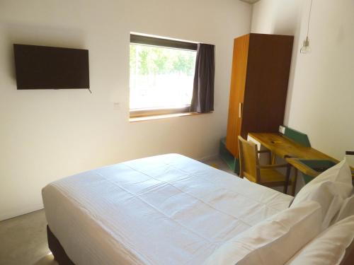 Schlafzimmer mit einem Bett, einem Schreibtisch und einem Fenster in der Unterkunft Hôtel Belvue in Brüssel