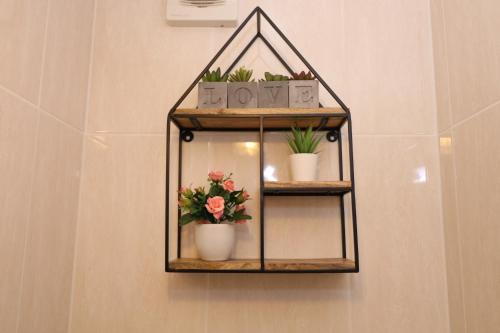 a shelf with plants and flowers on a wall at The Lavenders in Bracknell