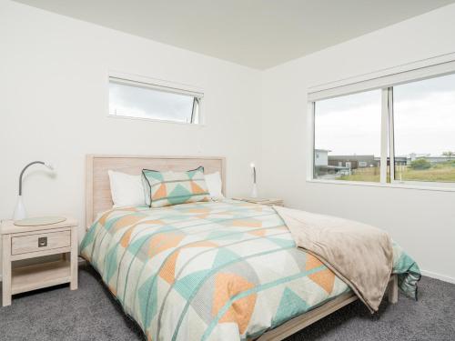 a white bedroom with a bed and a window at Ruakaka Sands - Ruakaka Holiday Home in Ruakaka