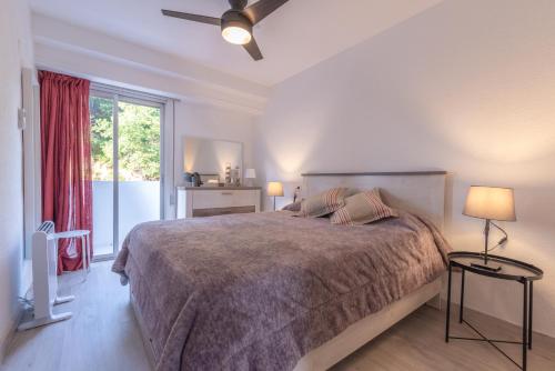 sypialnia z dużym łóżkiem i oknem w obiekcie Mirando al Mar w Alicante