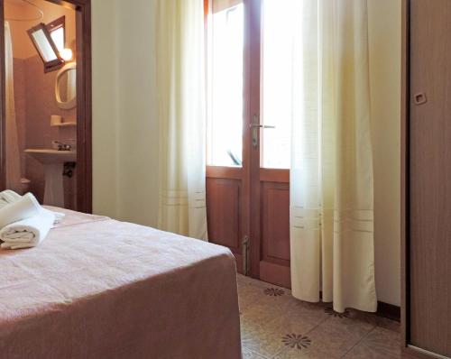a bedroom with a bed and a large window at Hotel Saturno in Lido di Jesolo